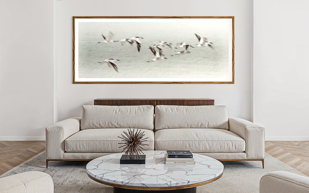 Modern interior featuring a framed artwork of a Flock of birds flying against a light blue sky by Francoise V Fine Art Gallery in Cape Town, South Africa