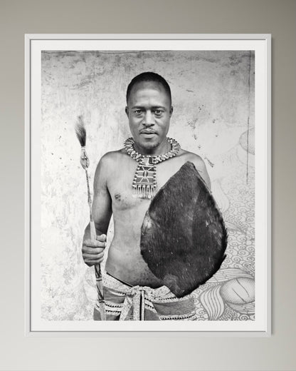 White box-framed Black and white portrait of a man holding a shield and spear against a textured wall by Francoise V Fine Art Gallery in Cape Town, South Africa